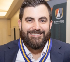 Smiling Caucasian male with beard in a navy blue suit jacket